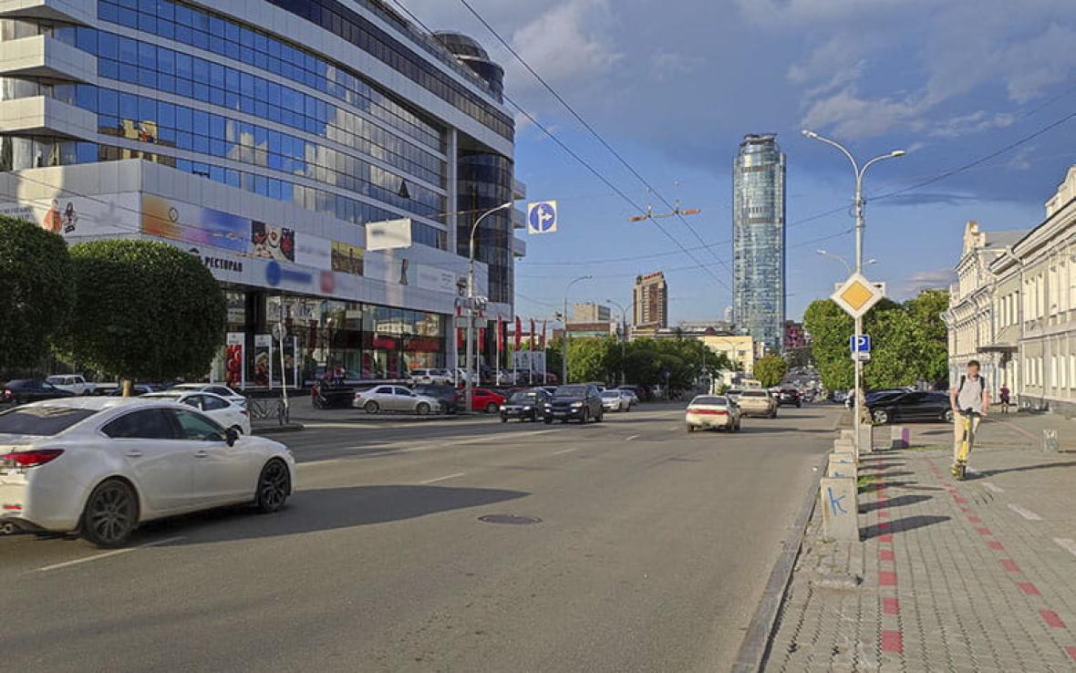 авто на оживленой дороге в городе среди многоэтажных зданий