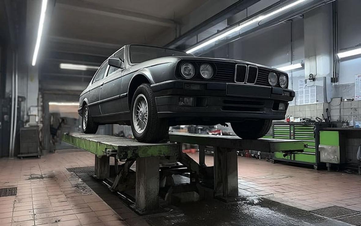 автомобиль в гараже на подъемнике для осмотра