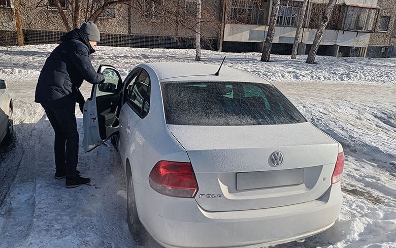 мужчина открывает дверь белой машины
