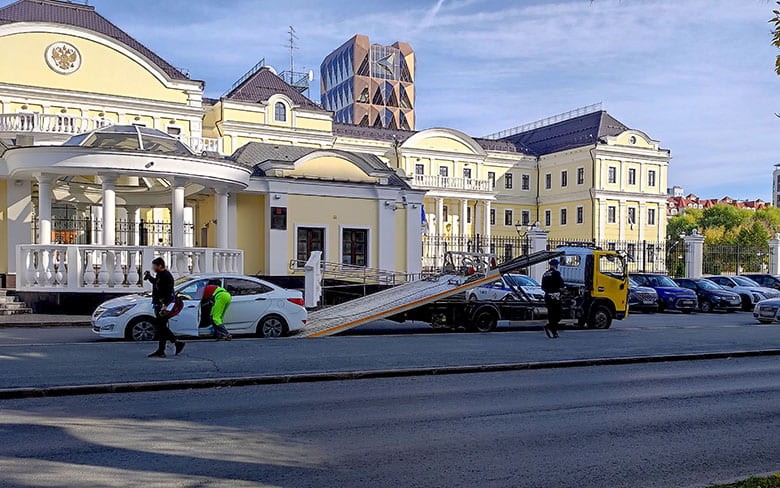 эвакуатор забирает машину с парковки