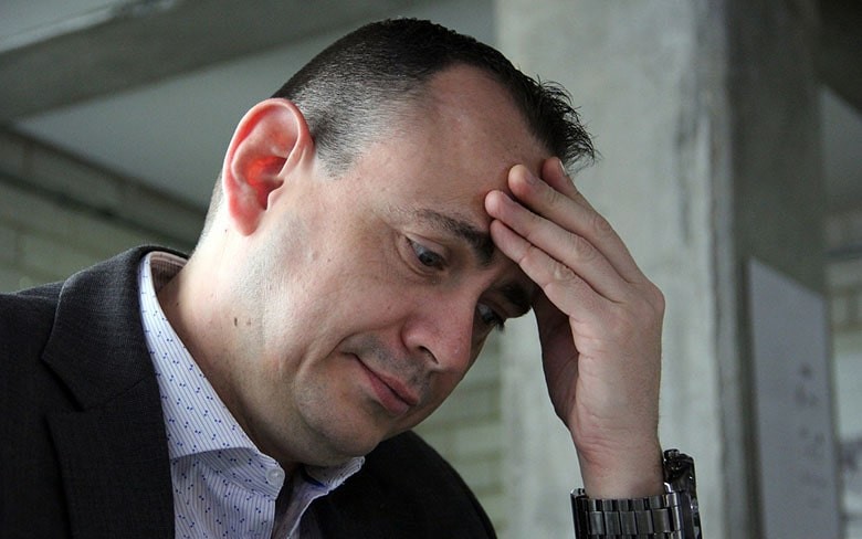 мужчина держится за голову